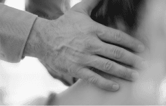 Hand assessing a patient's neck after whiplash