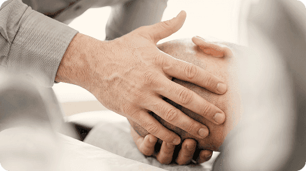 Hands treating a patient's head and jaw