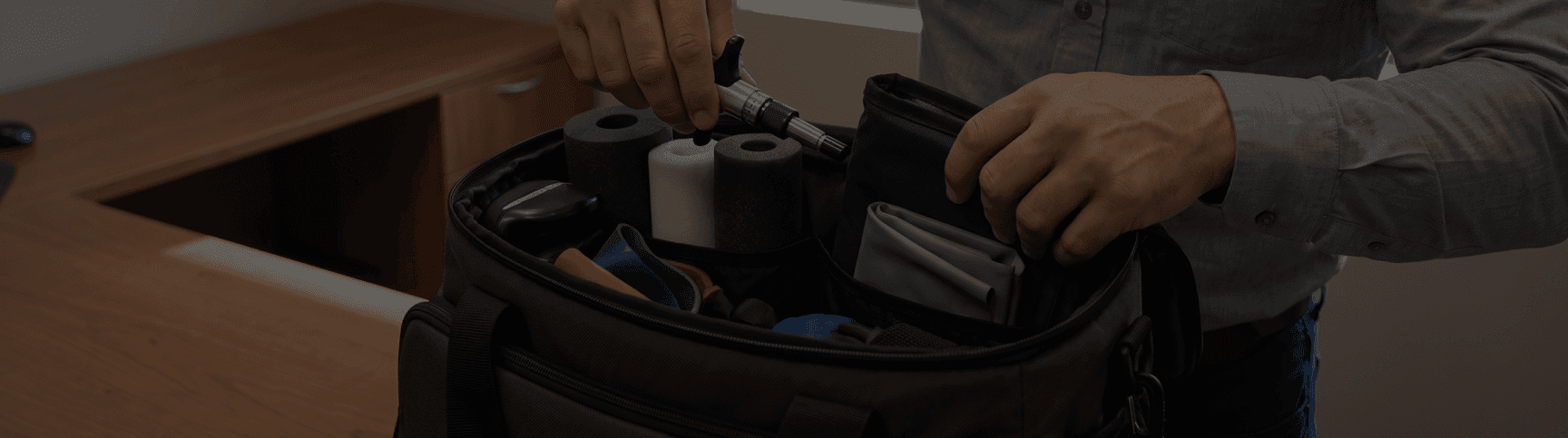 A therapist selecting massage tools from a bag of soft-tissue equipment